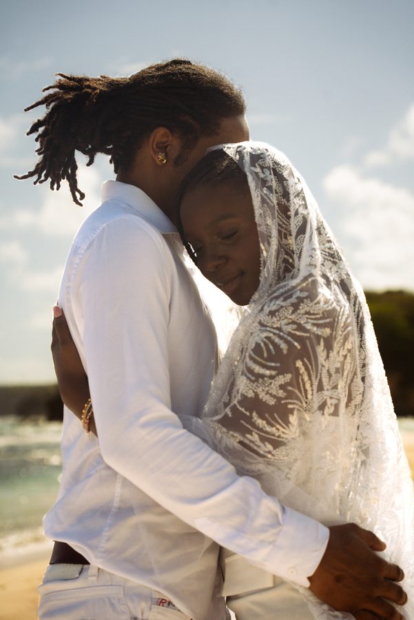 Couple enlacé, voile en dentelle, plage